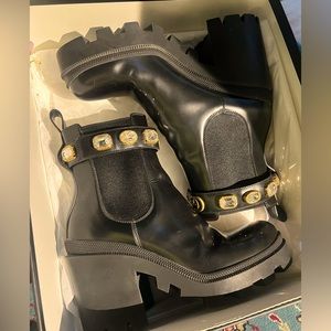 Ankle boots in shinny black leather with detachable ankle strap with crystals.